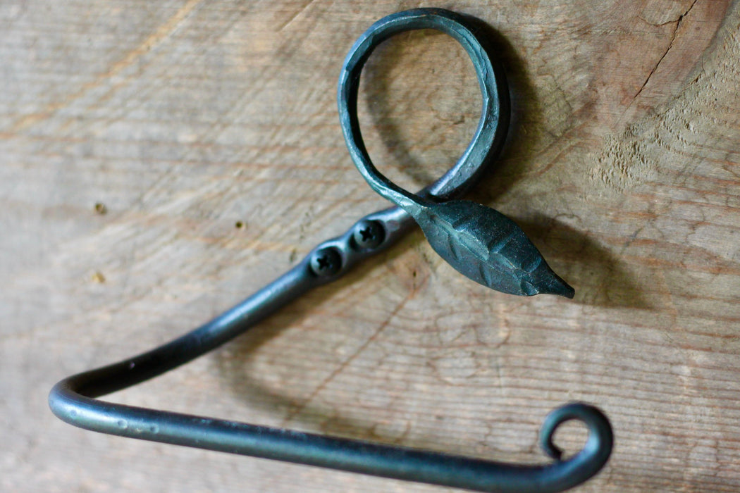 a blacksmith hand forged toilet paper holder with a leaf detail by Wicks Forge