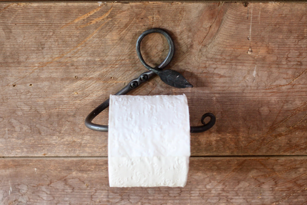 a blacksmith hand forged toilet paper holder with a leaf detail by Wicks Forge