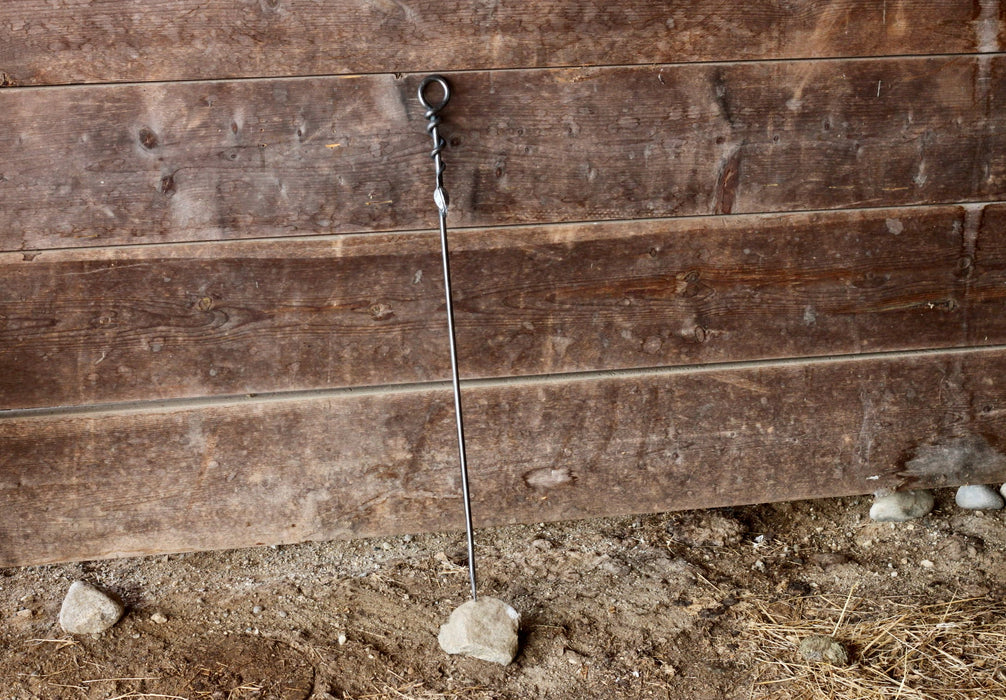 a blacksmith hand forged fire poker with a leaf wrap design by Wicks Forge