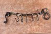 a blacksmith hand forged pot and pan rack with a leaf design by Wicks Forge