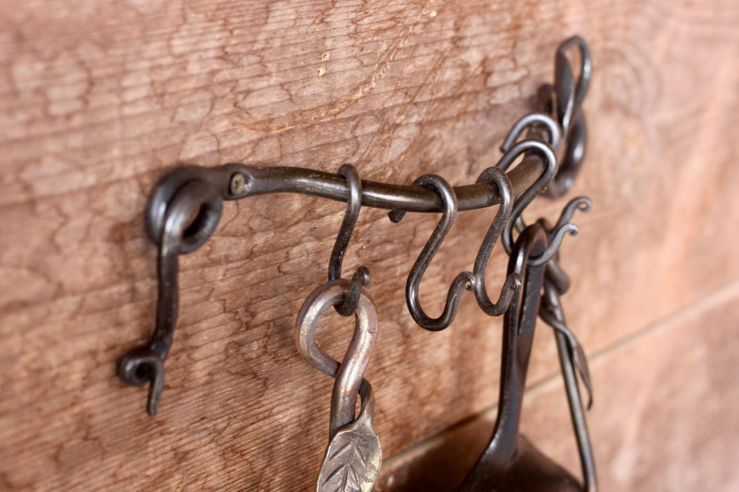 a blacksmith hand forged pot and pan rack with a leaf design by Wicks Forge