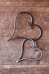 a pair of blacksmith hand forged linked hearts by Wicks Forge