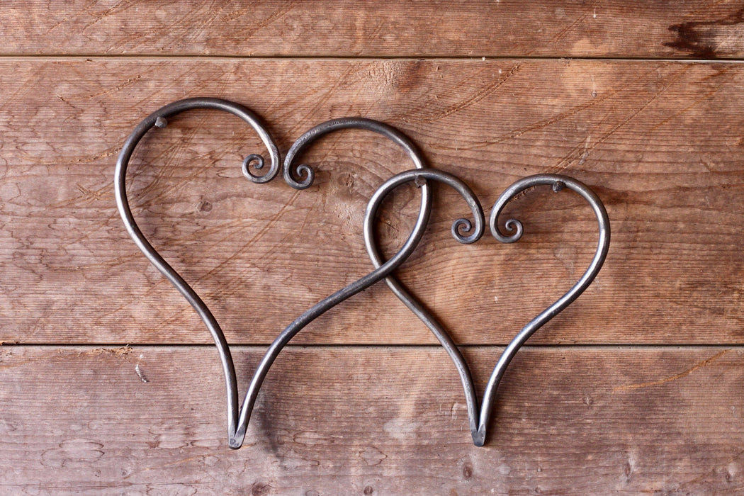 a pair of blacksmith hand forged linked hearts by Wicks Forge