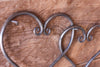 a pair of blacksmith hand forged linked hearts by Wicks Forge