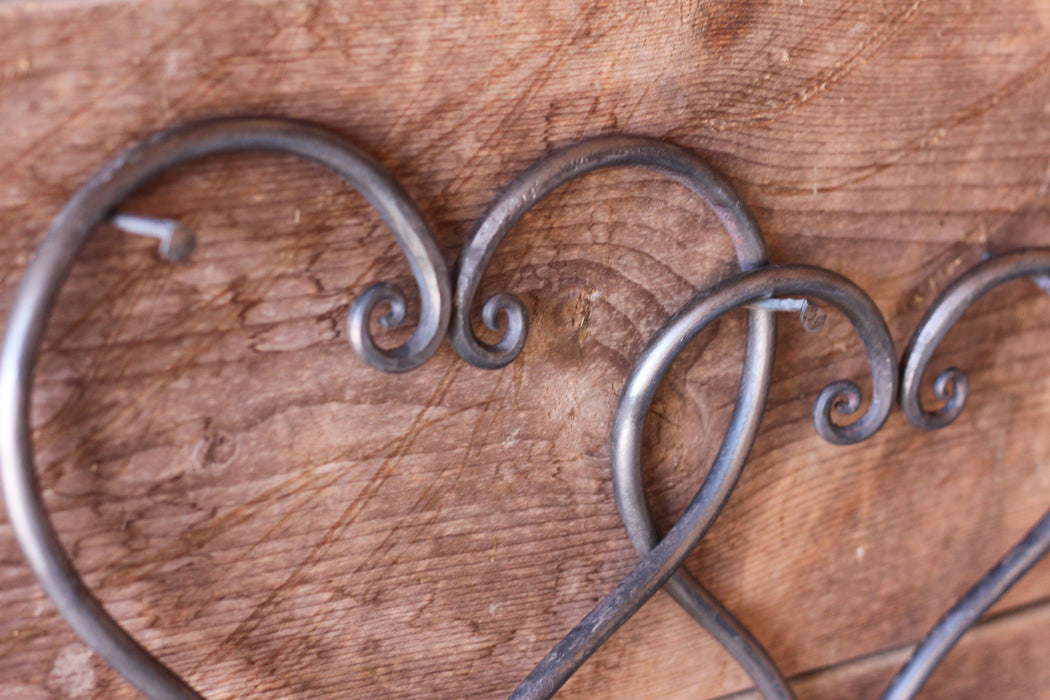 a pair of blacksmith hand forged linked hearts by Wicks Forge