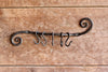 a blacksmith hand forged pot and pan holder with a scrolled design by Wicks Forge