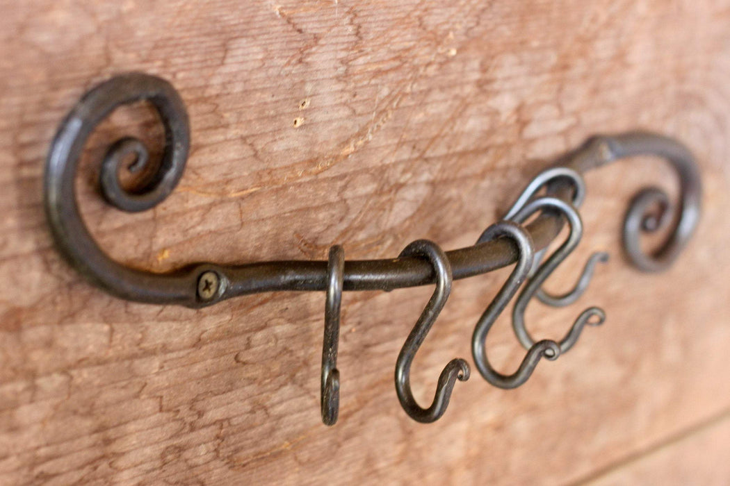 a blacksmith hand forged pot and pan holder with a scrolled design by Wicks Forge