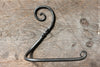 a blacksmith hand forged toilet paper holder with a curl detail by Wicks Forge